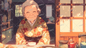 AA-0817A smiling elderly woman wearing a floral kimono behind a wooden sliding door